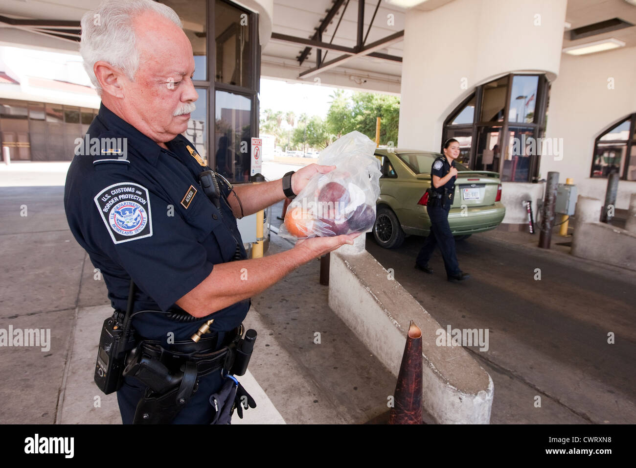 Männliche Offizier hält Beutel mit eingezogenen Frucht brachten aus Mexiko an der internationalen Brücke Laredo, Texas Stockfoto