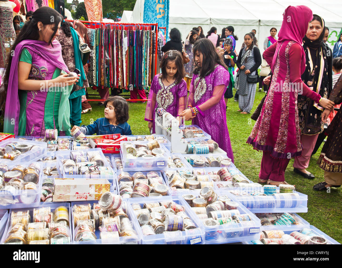 Asiatische Frau Prüfung Armreifen für Verkauf auf dem Basar-Markt im Edinburgh Mela, ein multikulturelles Festival auf Leith Link Stockfoto
