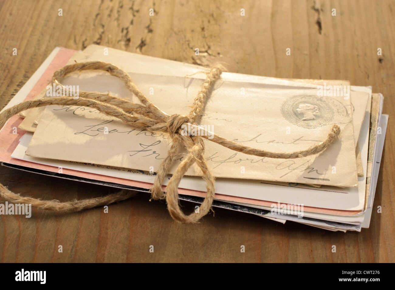 Bündel von Briefen, die mit einer Schnur auf dem alten Holztisch gebunden Stockfoto