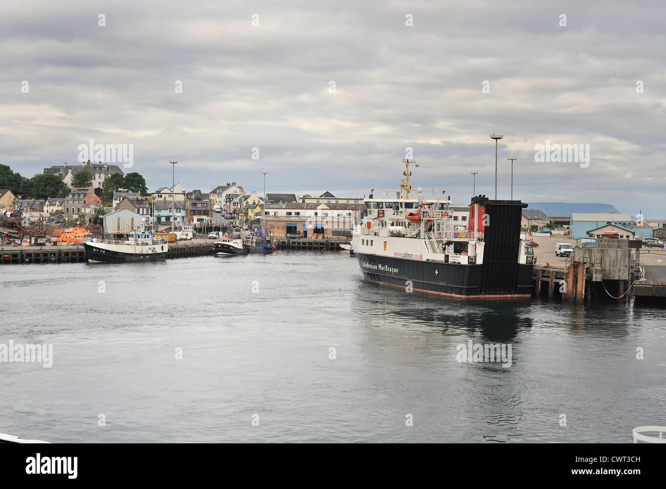 Fähre und Angelboote/Fischerboote im Hafen von Malaig mit Stadt im Hintergrund Stockfoto