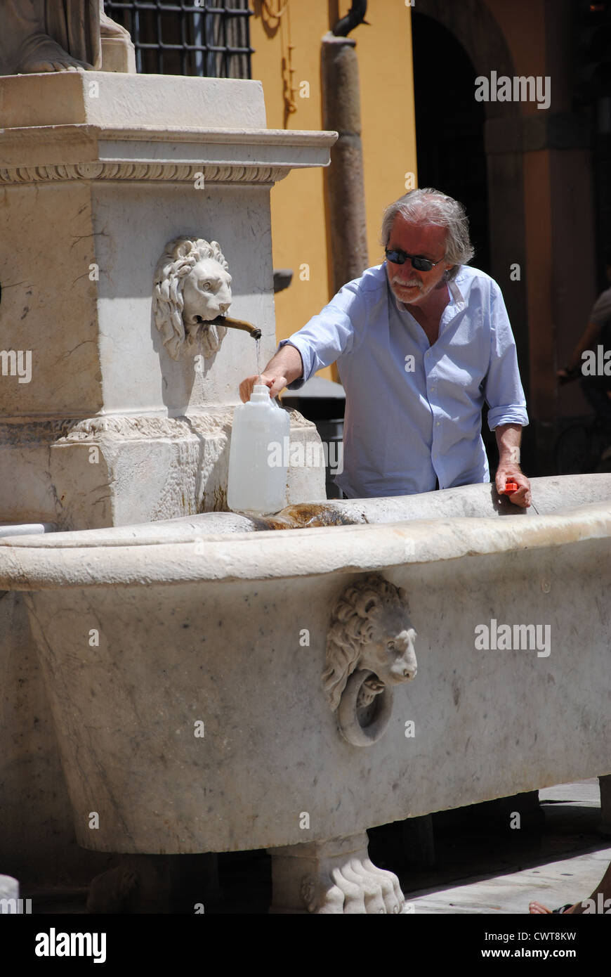 Italienischer Mann sammelt Wasser aus einem Brunnen in Lucca, Toskana Stockfoto