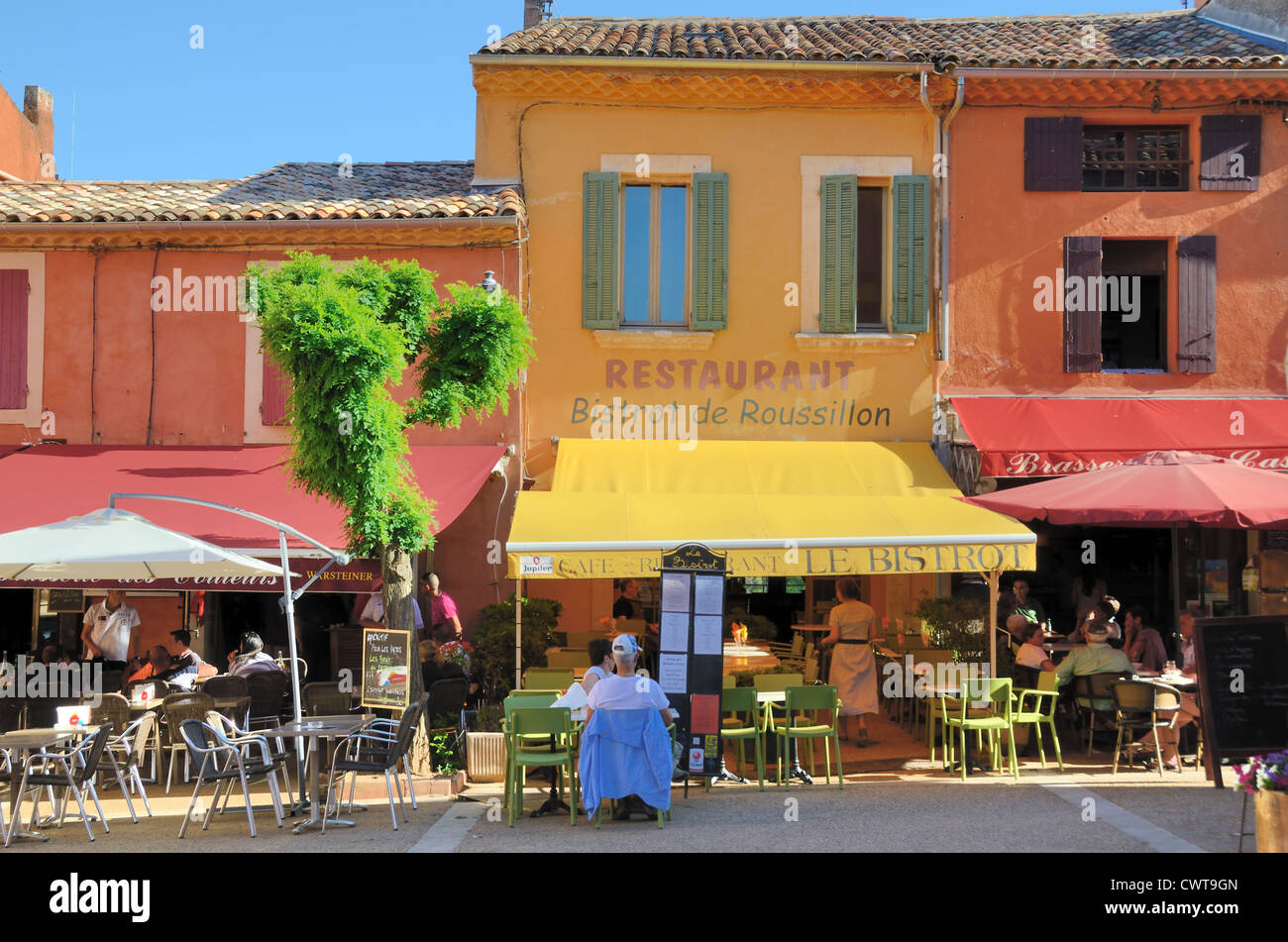 Bunte Restaurants im Dorf Hauptplatz Roussillon Luberon Vaucluse Provence Frankreich Stockfoto