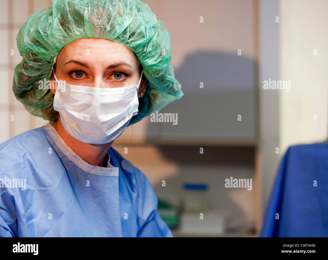 Ein Chirurg oder OP-Schwester schaut düster in die Kamera mit großen blauen Augen in Frage zu stellen. Stockfoto