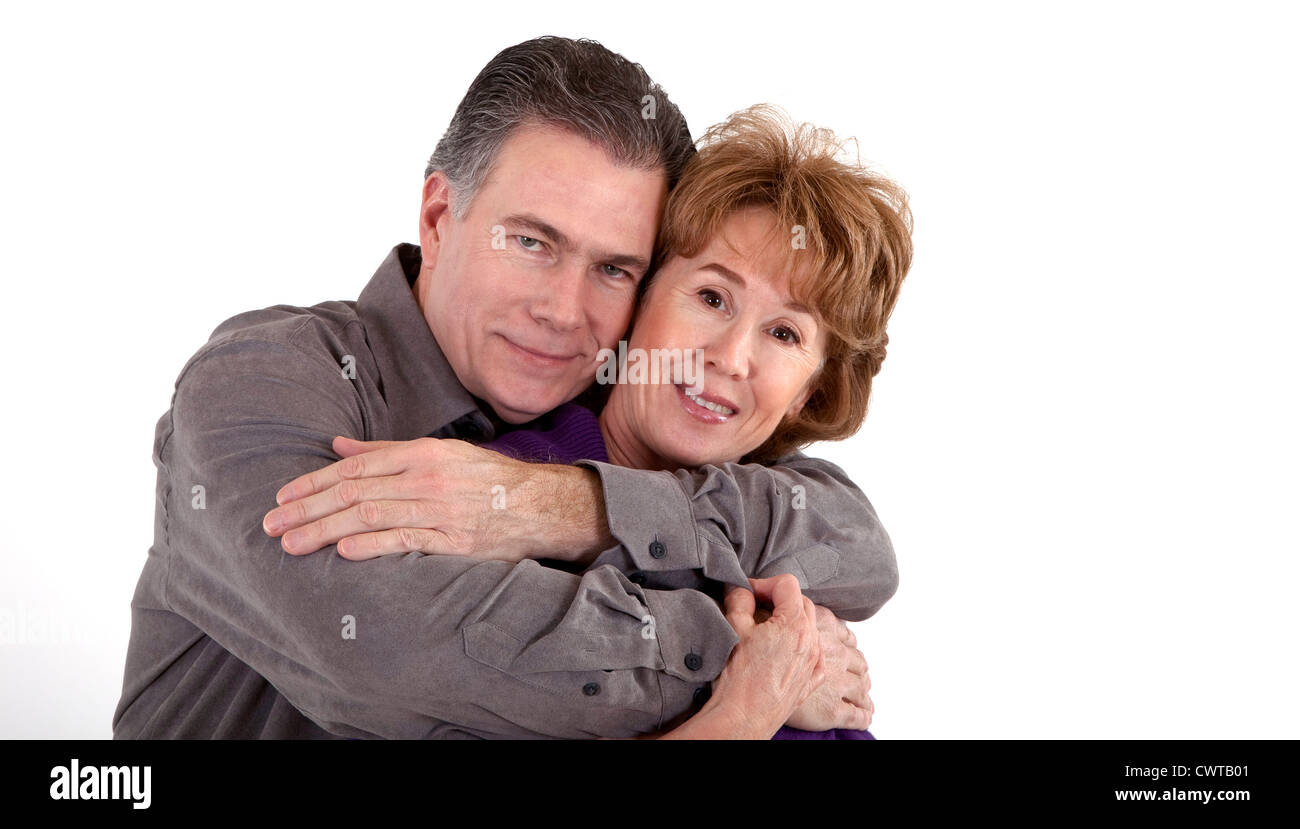 Ein älteres Paar in eine spielerische Umarmung Lächeln für die Kamera. Stockfoto