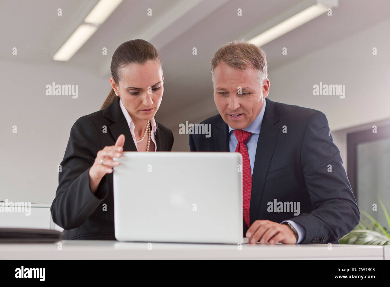 Unternehmer und Unternehmerin mit Laptop im Büro Stockfoto