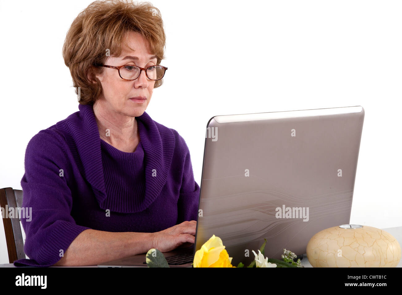 Eine reife Frau die scheint in was auch immer sie auf dem Bildschirm ihres Laptops sieht vertieft zu sein. Stockfoto