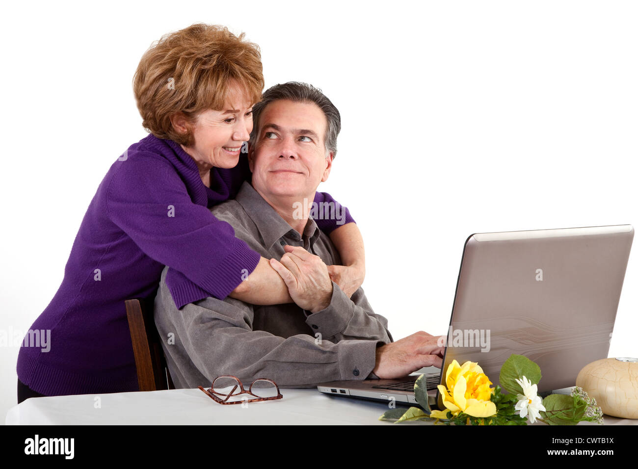 Ein Lächeln auf den Lippen älteres Paar an einem Computer sitzen. Stockfoto