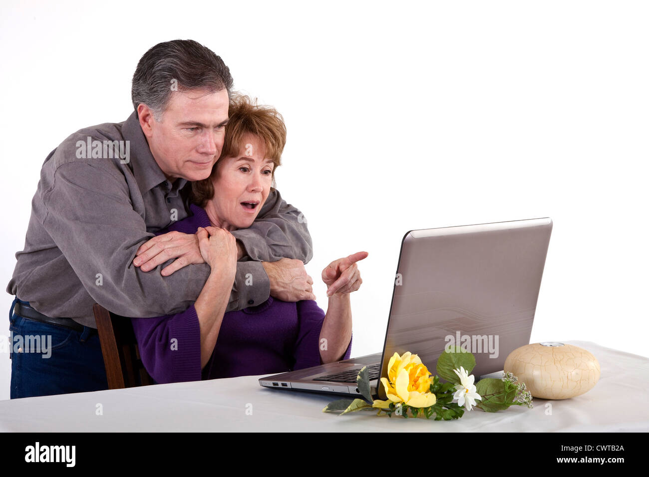 Ein älteres paar gelesen, dass etwas die Frau auf ihren Laptop-Bildschirm überraschend findet. Stockfoto