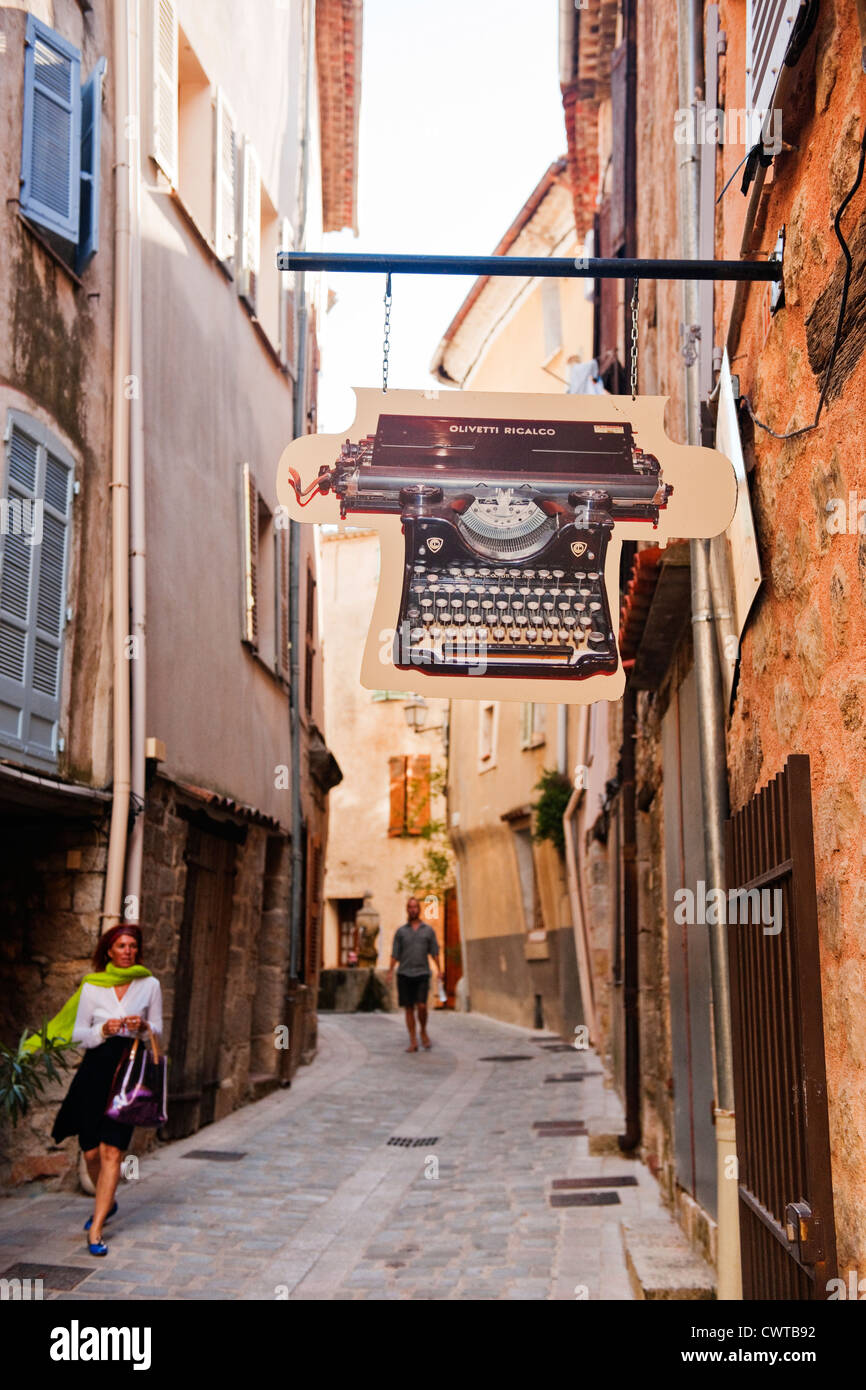 A Straßenszene in Bargemon Provence, Frankreich mit einer gut gekleideten Frau vorbeigehen ein Olivetti Schreibmaschine Zeichen für ein museum Stockfoto