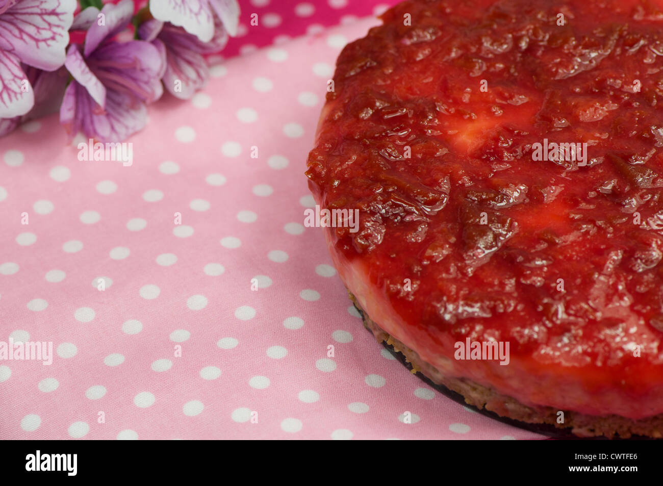 handgemachte Pflaumenkuchen erschossen auf einem rosa Tischdecke mit Blume Stockfoto