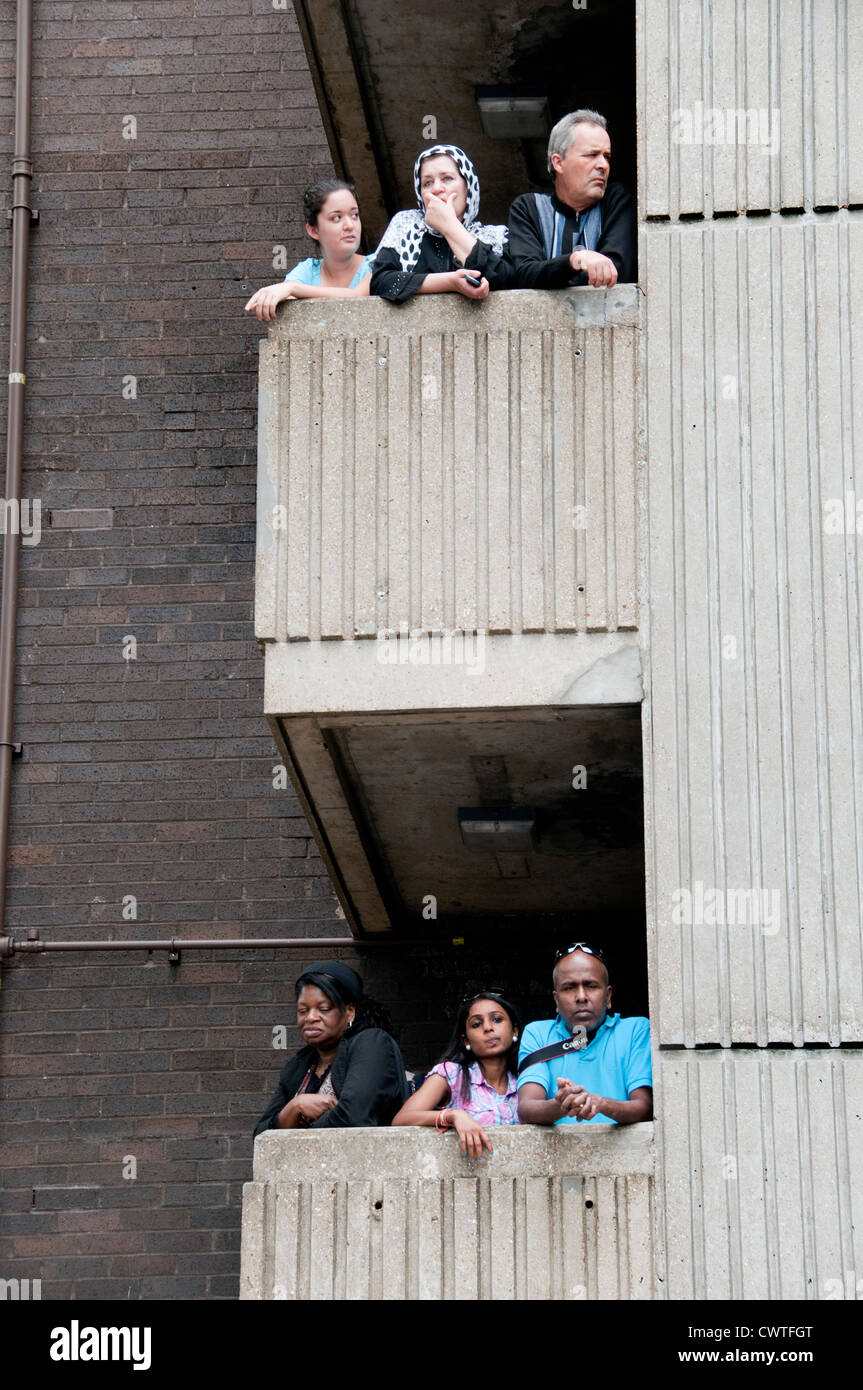 High-Rise Wohnanlagen mit Menschen draußen auf dem Balkon beobachten Notting Hill Carnival vorbeiziehen Stockfoto