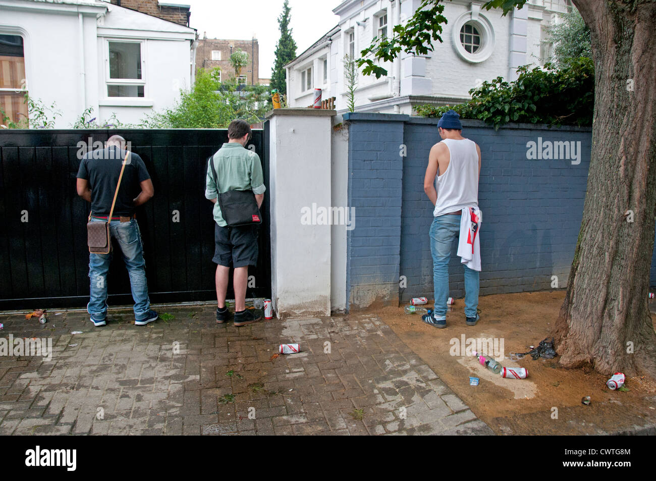 Männer urinieren gegen Wand in Notting Hill Carnival Stockfotografie