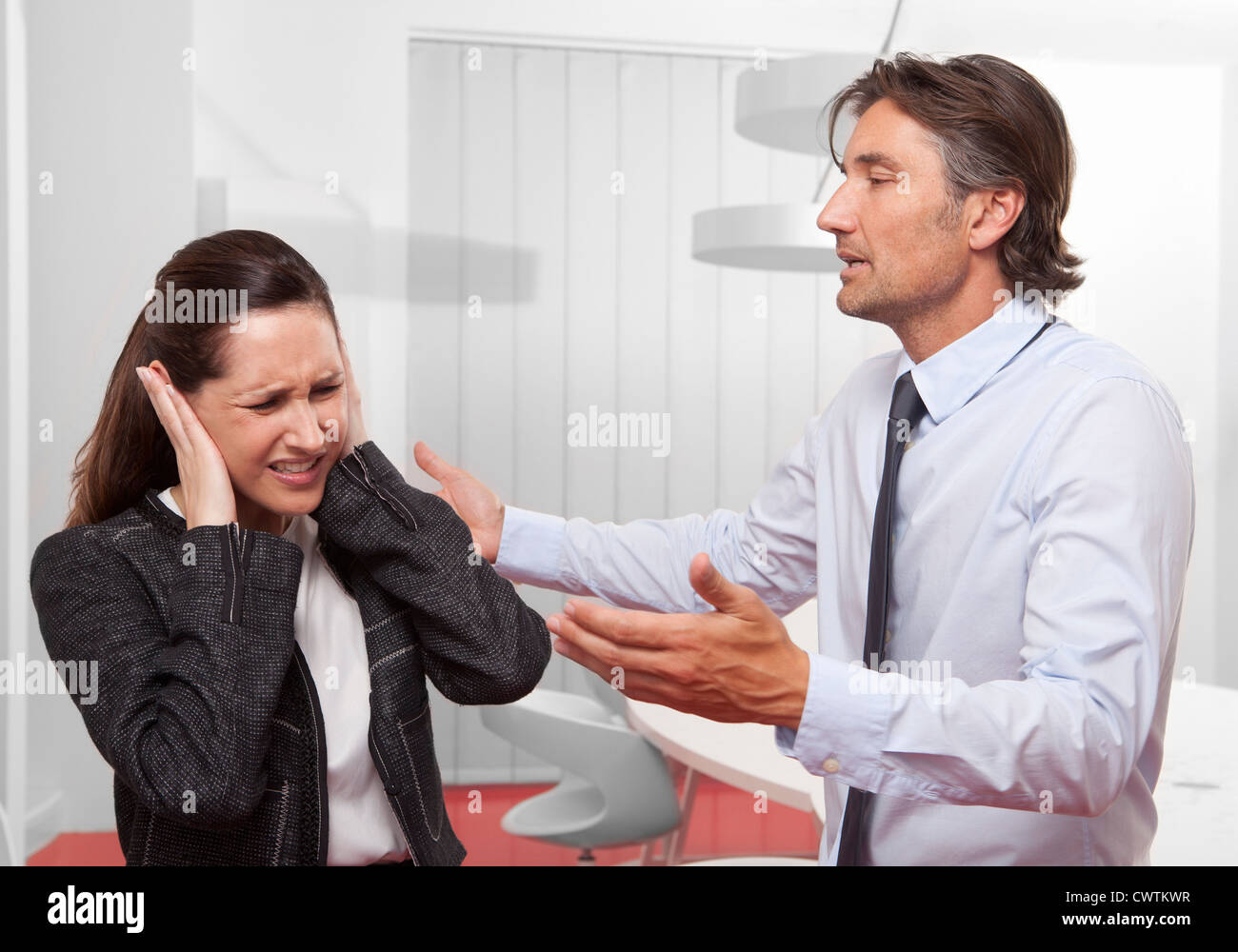Unternehmer im Gespräch mit Frau für ihre Ohren Stockfoto