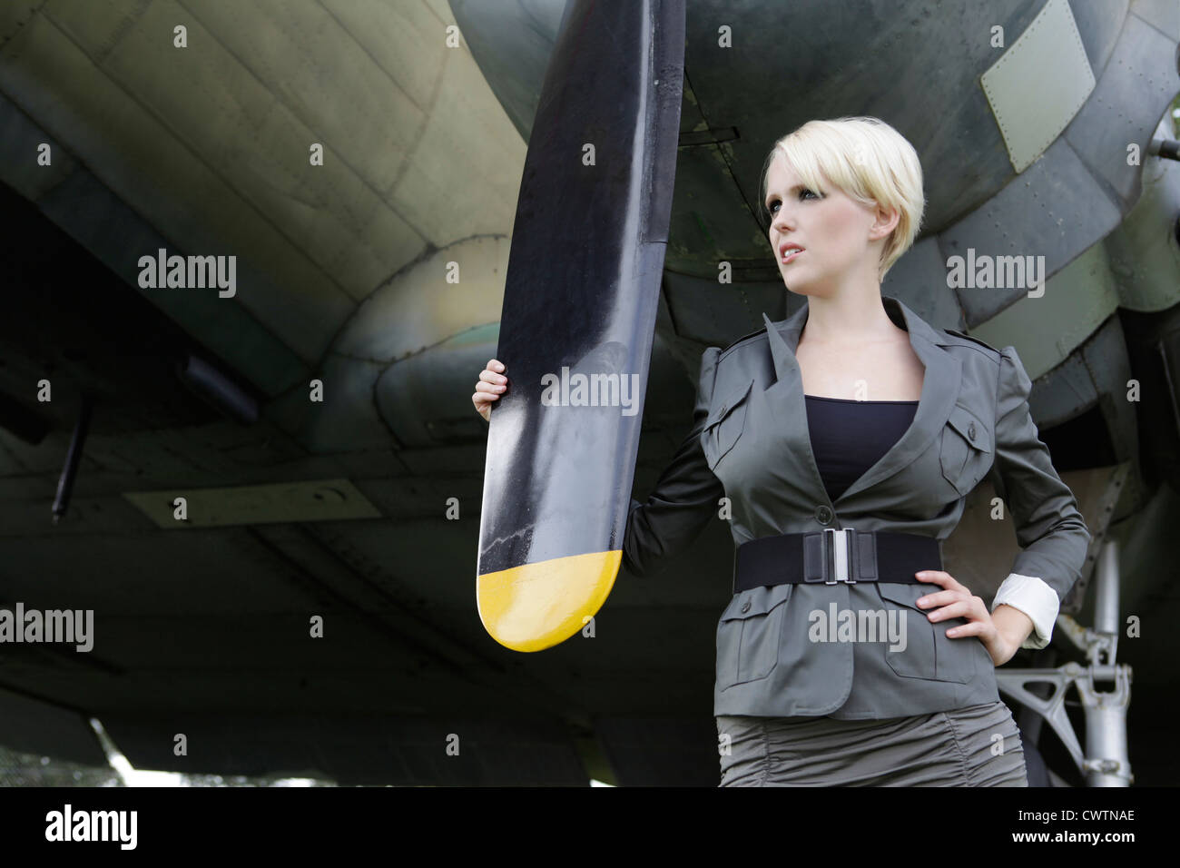 Junge Frau am Propeller-Flugzeug Stockfoto