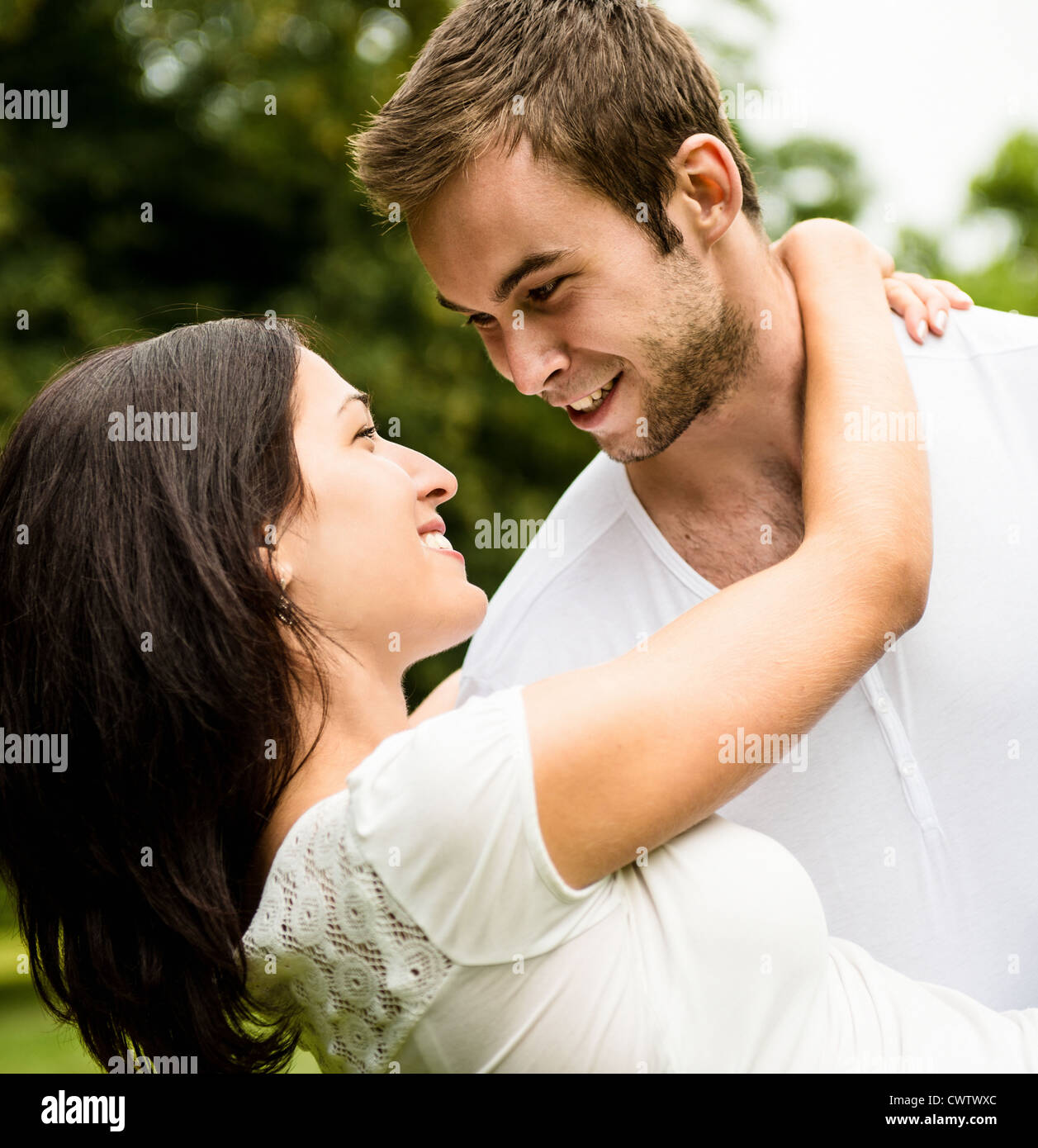 Glückliches junges Paar - Mann trägt Frau das Leben zu genießen Stockfoto