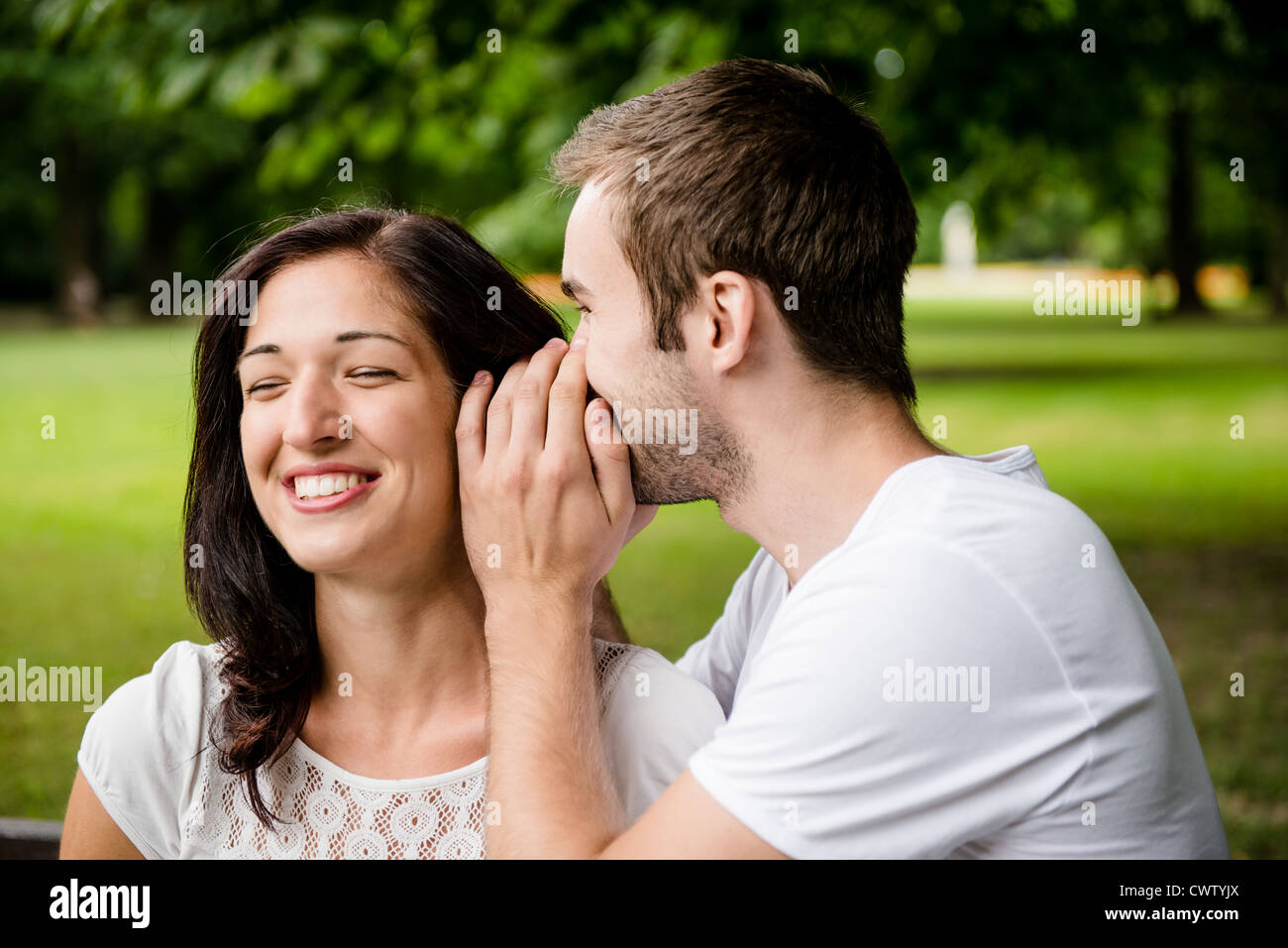 Junger Mann, flüsterte Frau (Freundin) - outdoor-Lifestyle Foto Stockfoto
