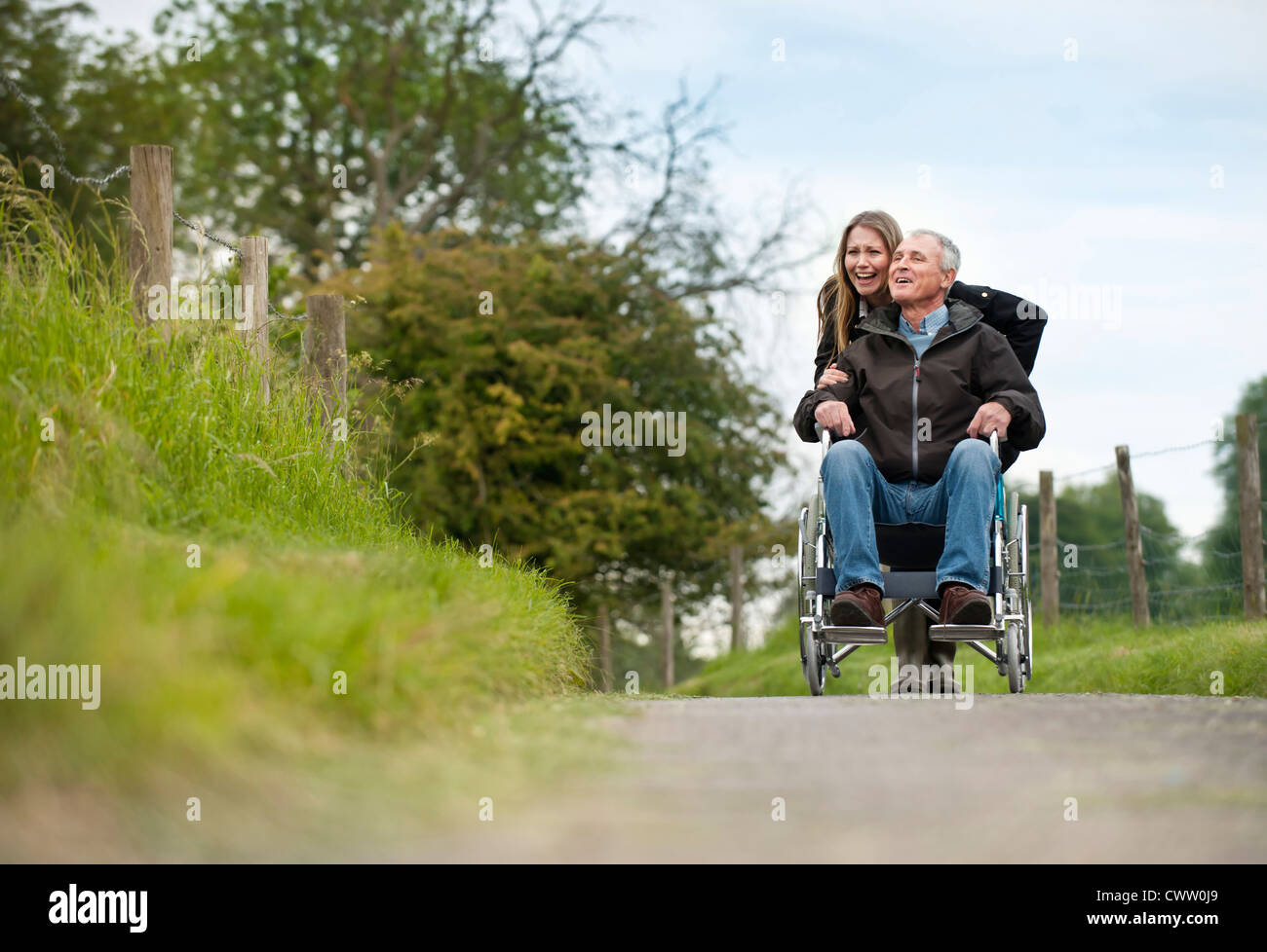 Frau drängen Vater im Rollstuhl Stockfoto