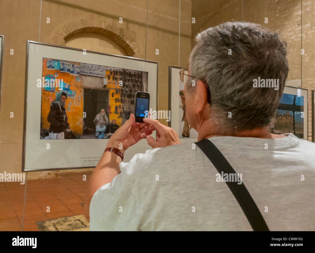 Perpignan, Frankreich, Mann nimmt Fotos mit Smart Phone in Fotoausstellungen, bei Visa Pour l ' Image International Fotojournalist Photography Festival Stockfoto