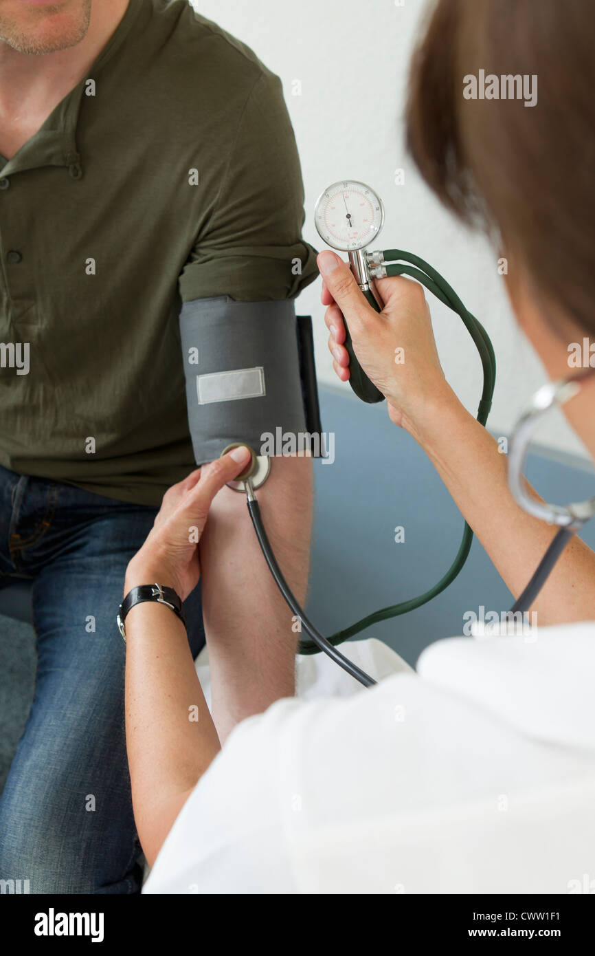 Arzt die Patienten Blutdruckmessung Stockfoto
