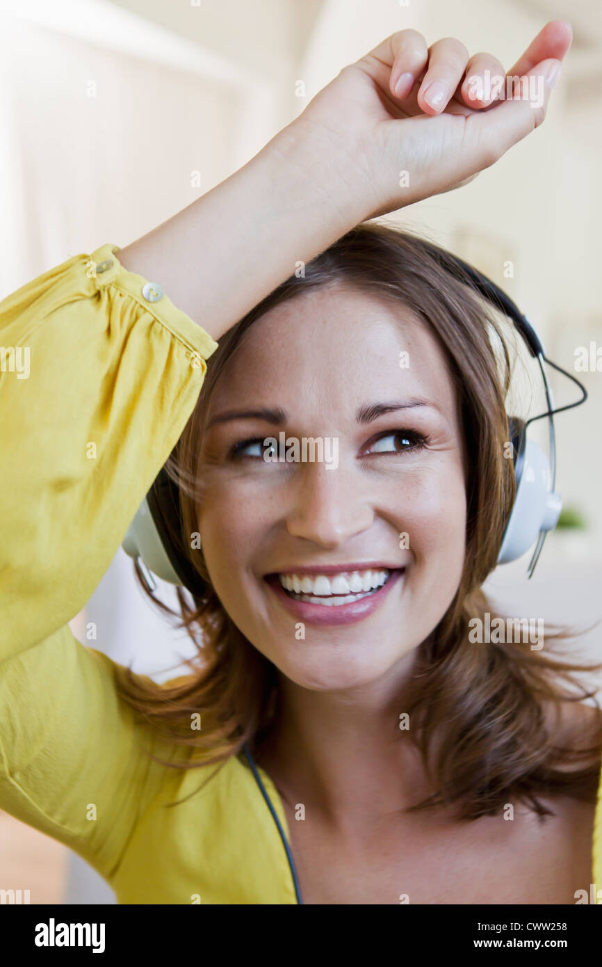 Lächelnde Frau Kopfhörer anhören Stockfoto
