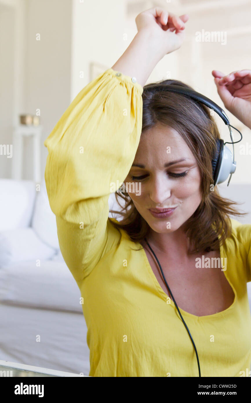 Lächelnde Frau tanzen zu Kopfhörer Stockfoto