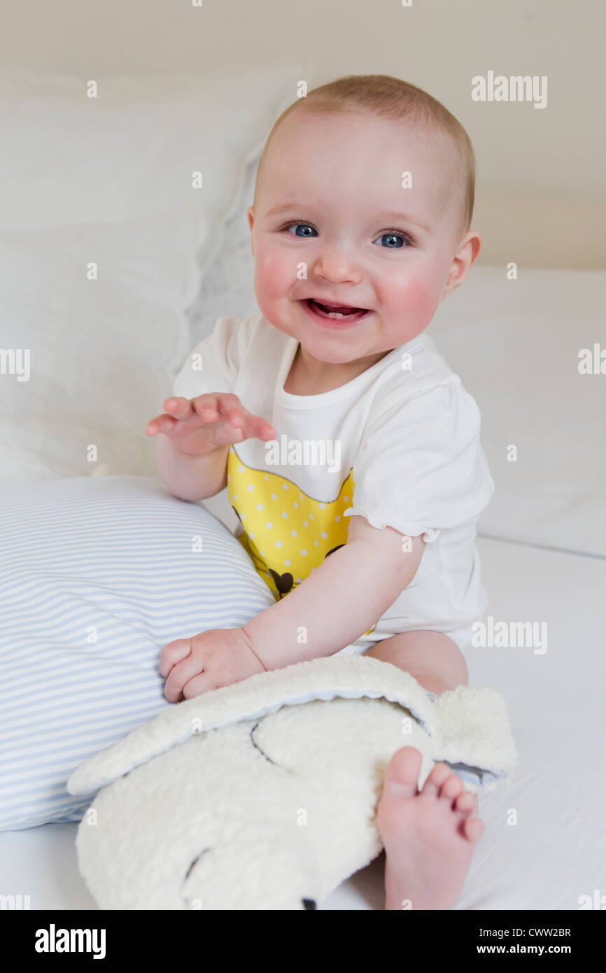 Lächelnden Baby sitzt auf Bett Stockfoto