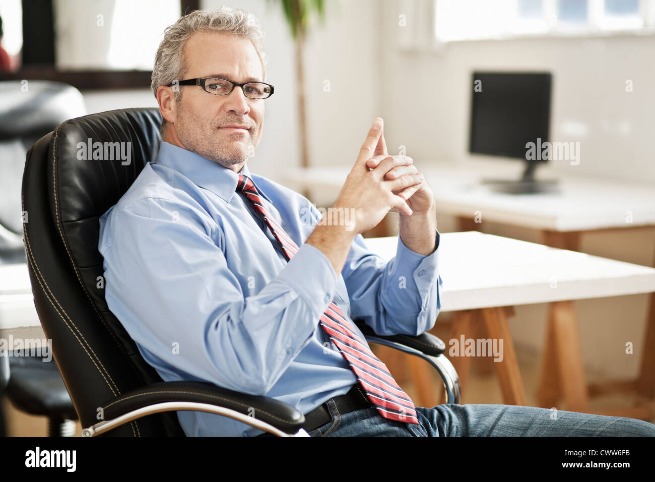 Lächelnde Geschäftsmann am Schreibtisch Stockfoto