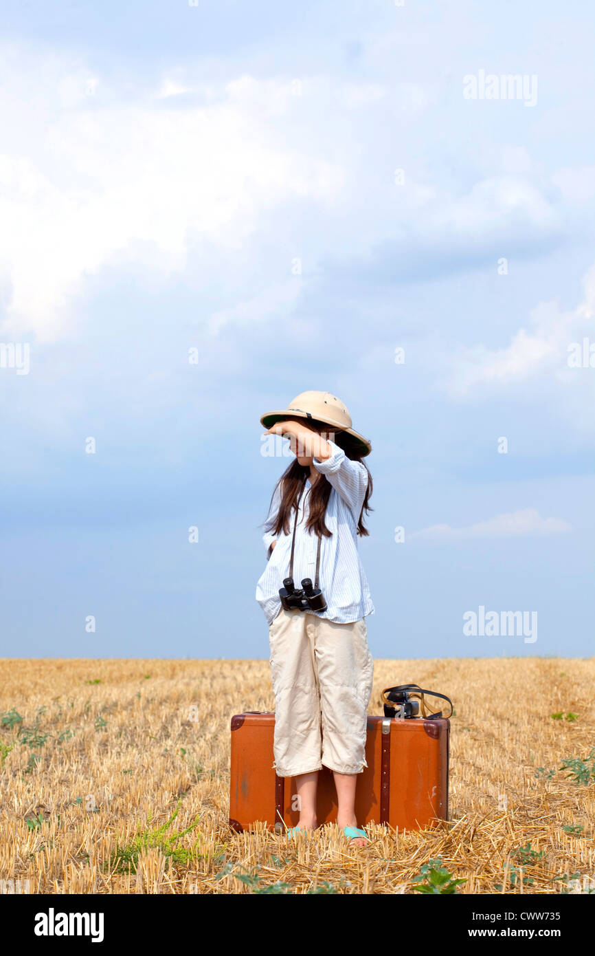 9 Jahre reisen Mädchen im Feld erntete mit alten Reisetasche. Stockfoto