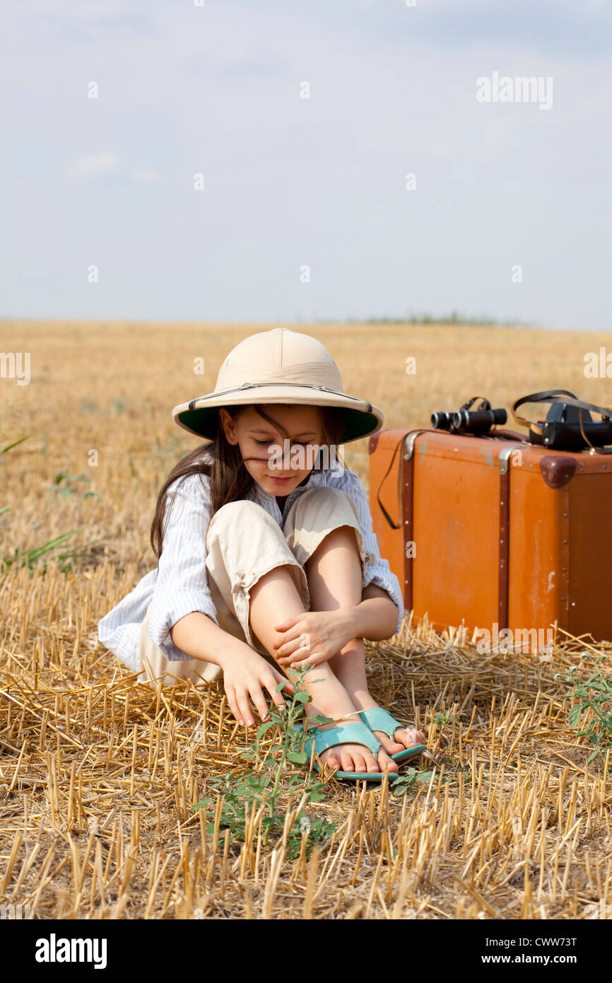 9 Jahre reisen Mädchen im Feld erntete mit alten Reisetasche. Stockfoto