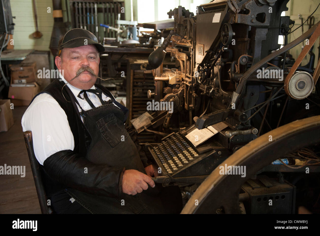 Mann mit Linotype-Modell 5 Linecasting Maschine in Druckerei in Billie Creek Village in Rockville, Indiana Stockfoto