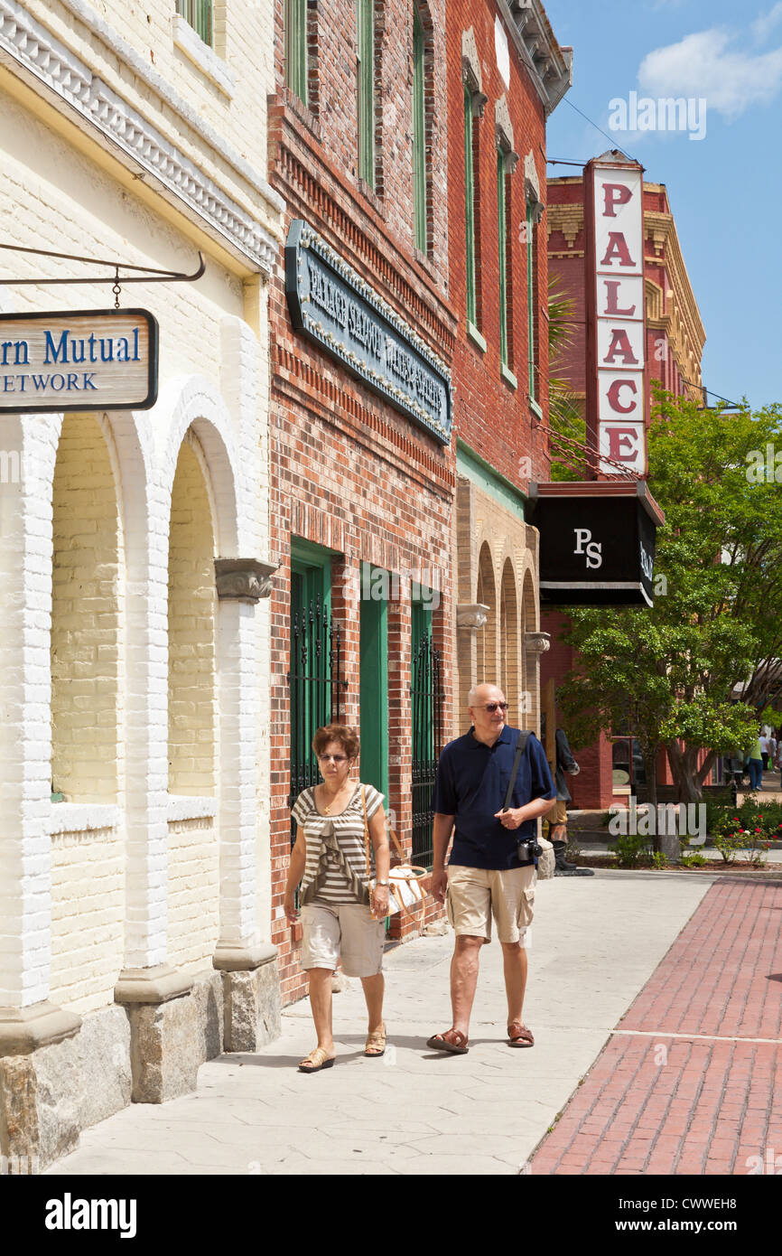 Ein Mann und eine Frau Fuß auf dem Bürgersteig vor dem Palace Saloon in Downtown Fernandina Beach auf Amelia Island in Florida Stockfoto