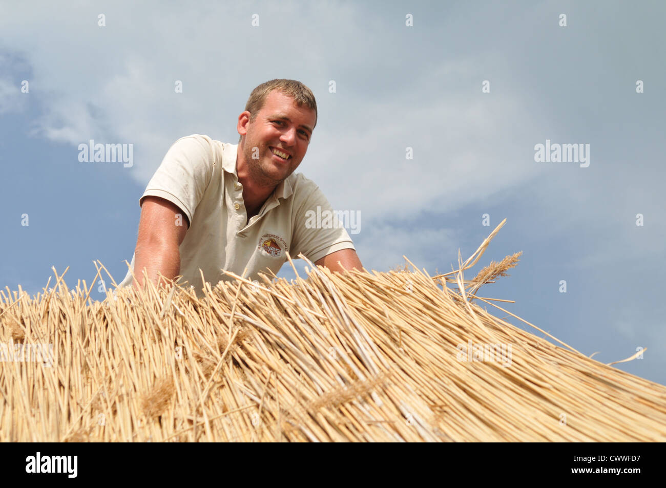 Mann arbeitet auf Stroh Dach Stockfoto