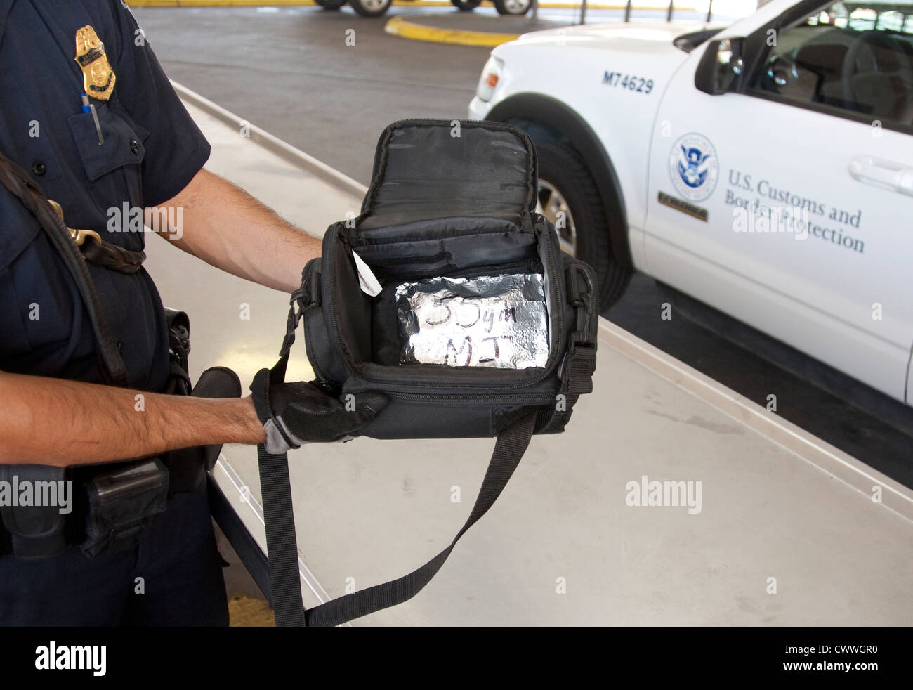 US Customs and Border Protection Officer hält Tasche enthält ein Paket von Marihuana zu trainieren Hunde zu schnuppern und Drogen zu finden Stockfoto