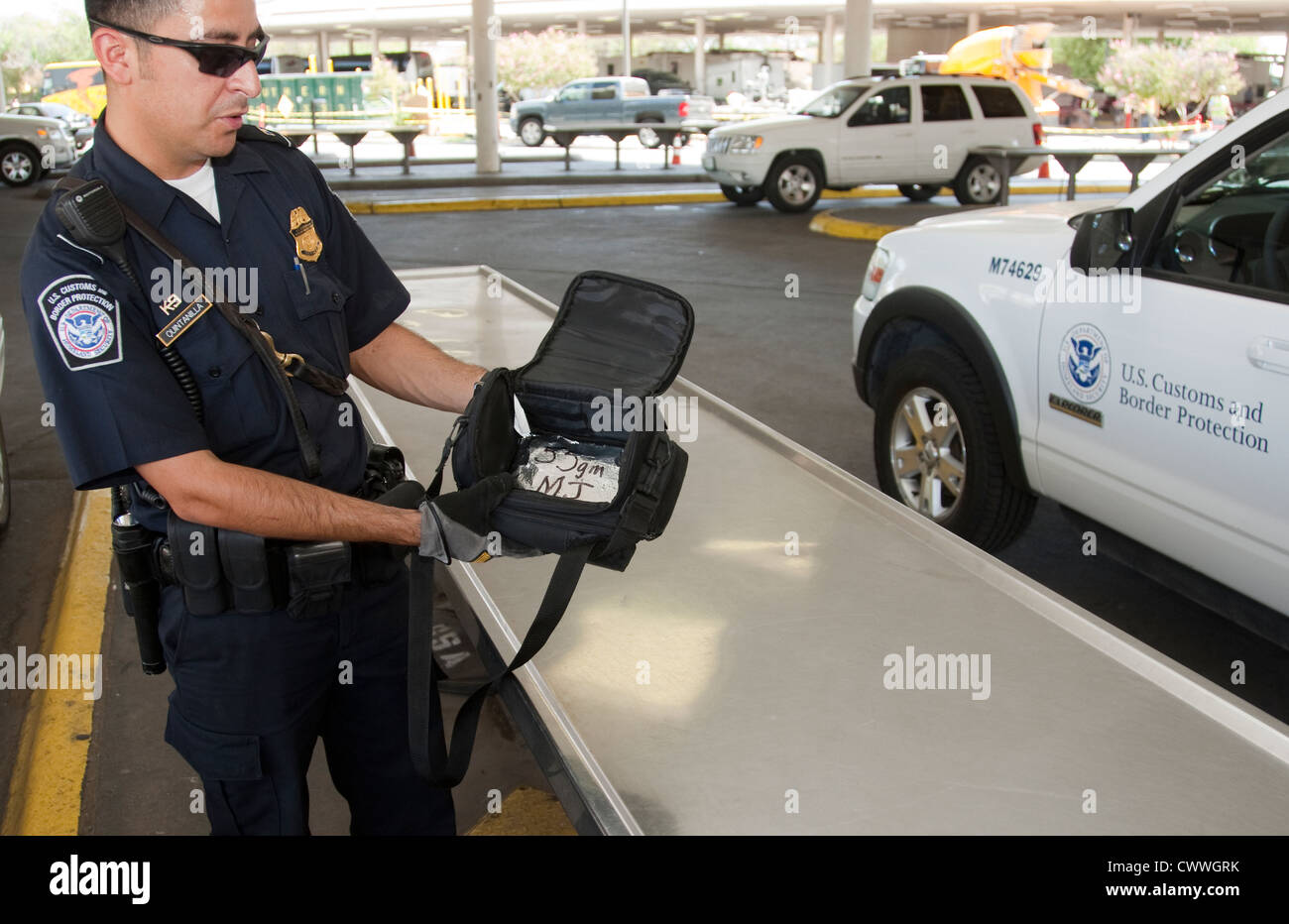 US Customs and Border Protection Officer hält Tasche enthält ein Paket von Marihuana zu trainieren Hunde zu schnuppern und Drogen zu finden Stockfoto