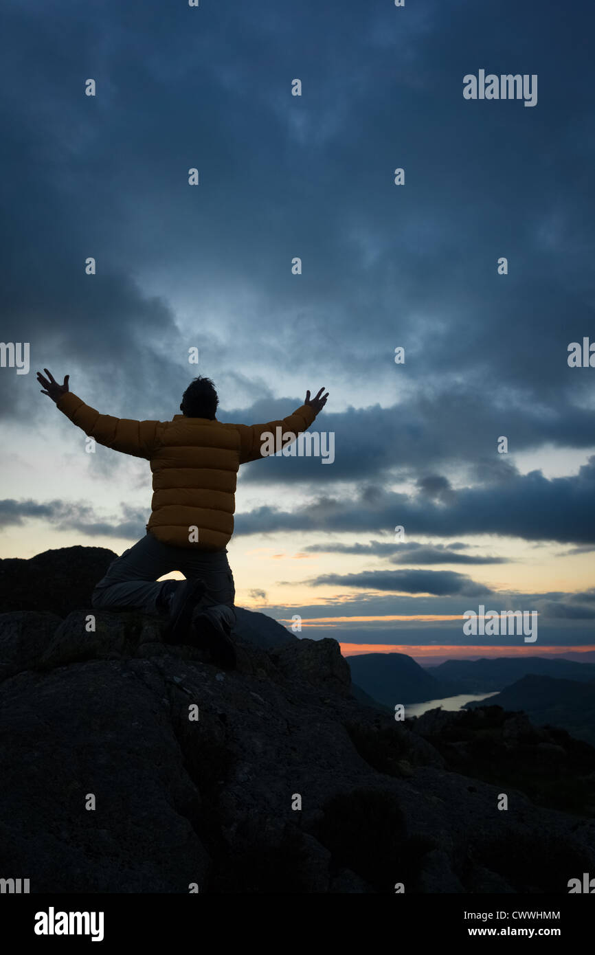 Ein Mann verehren Gott vom Gipfel eines Berges. Stockfoto