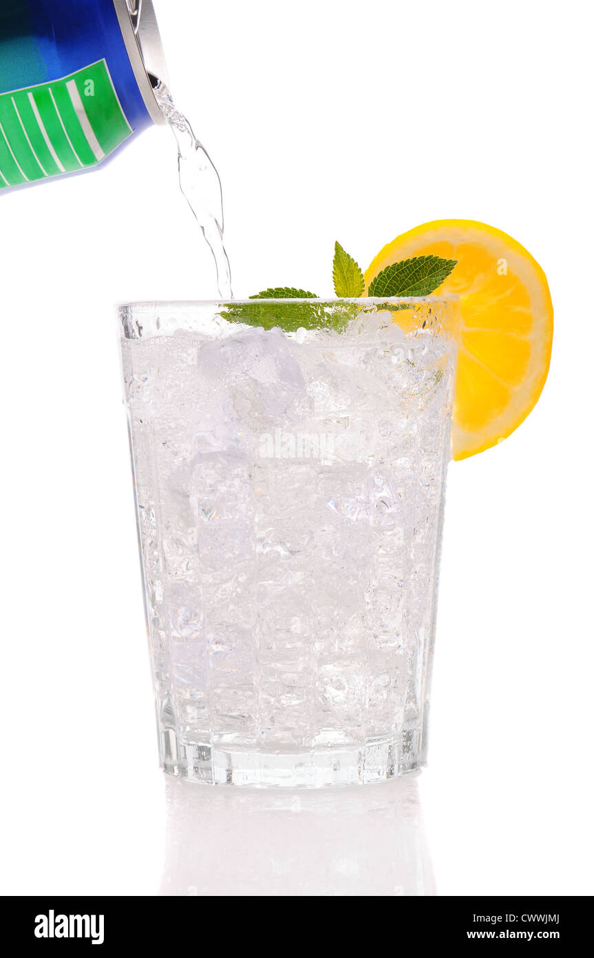Klare Soda aus der Dose in ein Glas gießen mit Eis gefüllt mit einem Zitronen-Keil und Minze-Zweig. Stockfoto