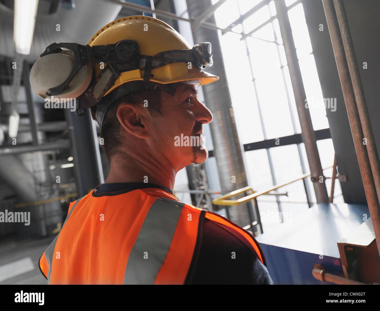 Arbeiter tragen Schutzhelm und Kopfhörer Stockfoto