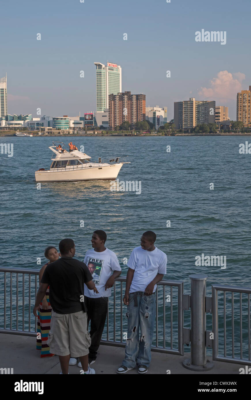 Young African-Americans hängen entlang den Detroit River, wie im mittleren Alter weißen auf einem Motorboot in der Nähe Kreuzfahrt Stockfoto