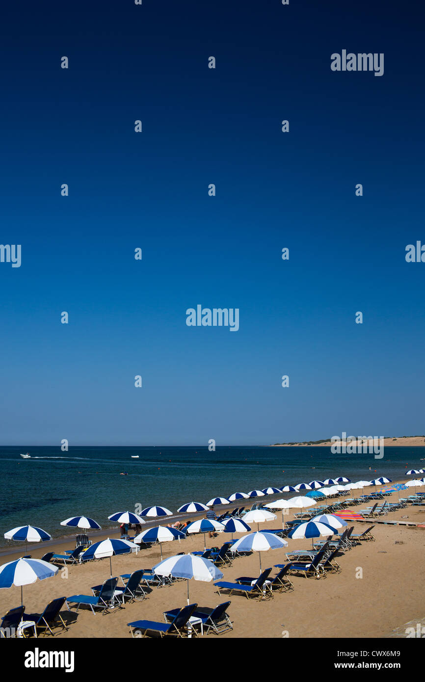 Eine Reihe von leeren farbige Liegestühle am Strand von Agios Georgios, Korfu, Ionische Inseln, Griechenland. Stockfoto