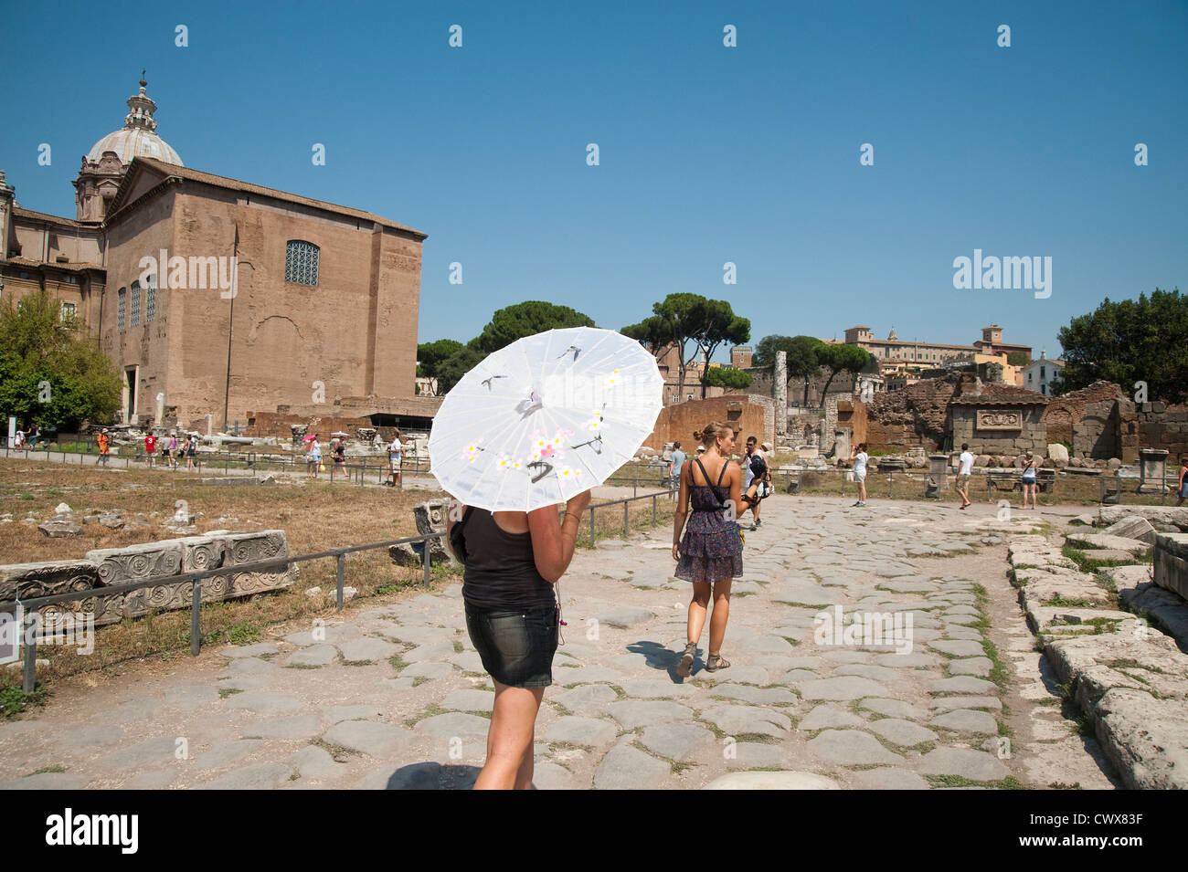 Rom, Italien - August 2012 - Frau Betrieb Sonnenschirm besuchen das Forum Romanum Stockfoto