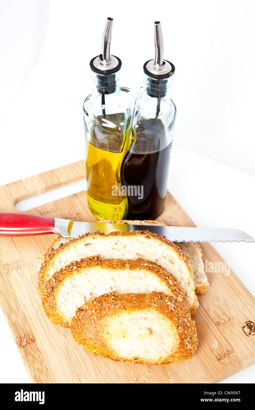 Schnittbrot auf ein Schneidebrett mit Messer und Öl und Essig. Stockfoto