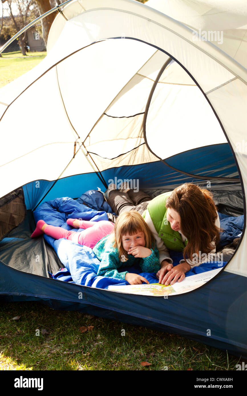 Mutter und Tochter liegen in einem Zelt lesen. Stockfoto