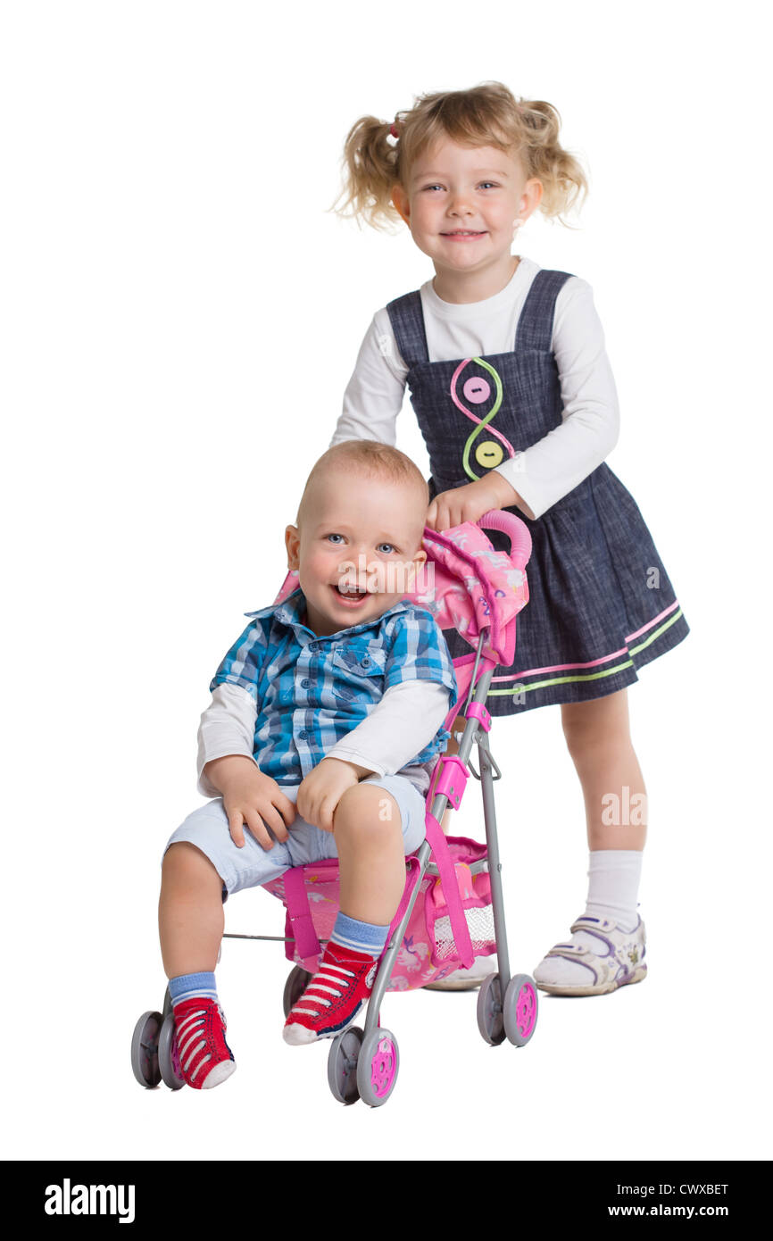 Kleine Mädchen ihren Bruder im Kinderwagen schieben Stockfoto