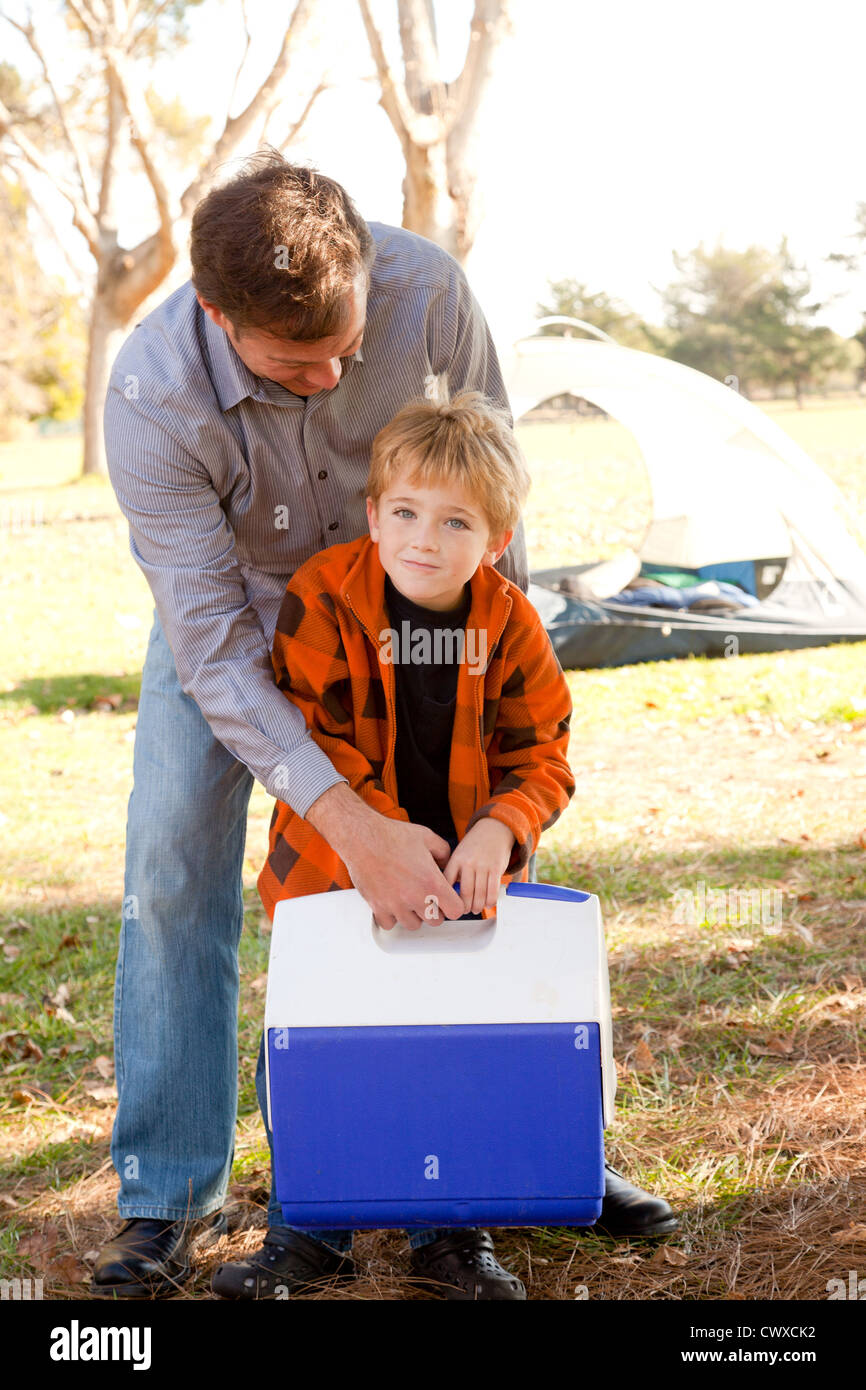 Ein Vater hilft seinem Sohn einen Kühler heben. Stockfoto
