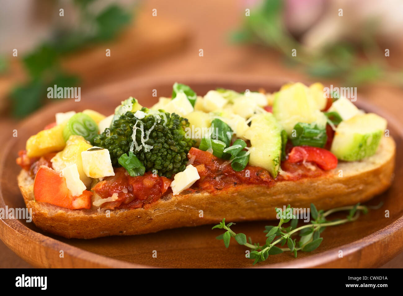 Gebackene vegetarische Open Sandwich (rote Paprika, Brokkoli, Zucchini, Lauch und Käse auf würzige Tomatensauce auf einem Brötchen) Stockfoto