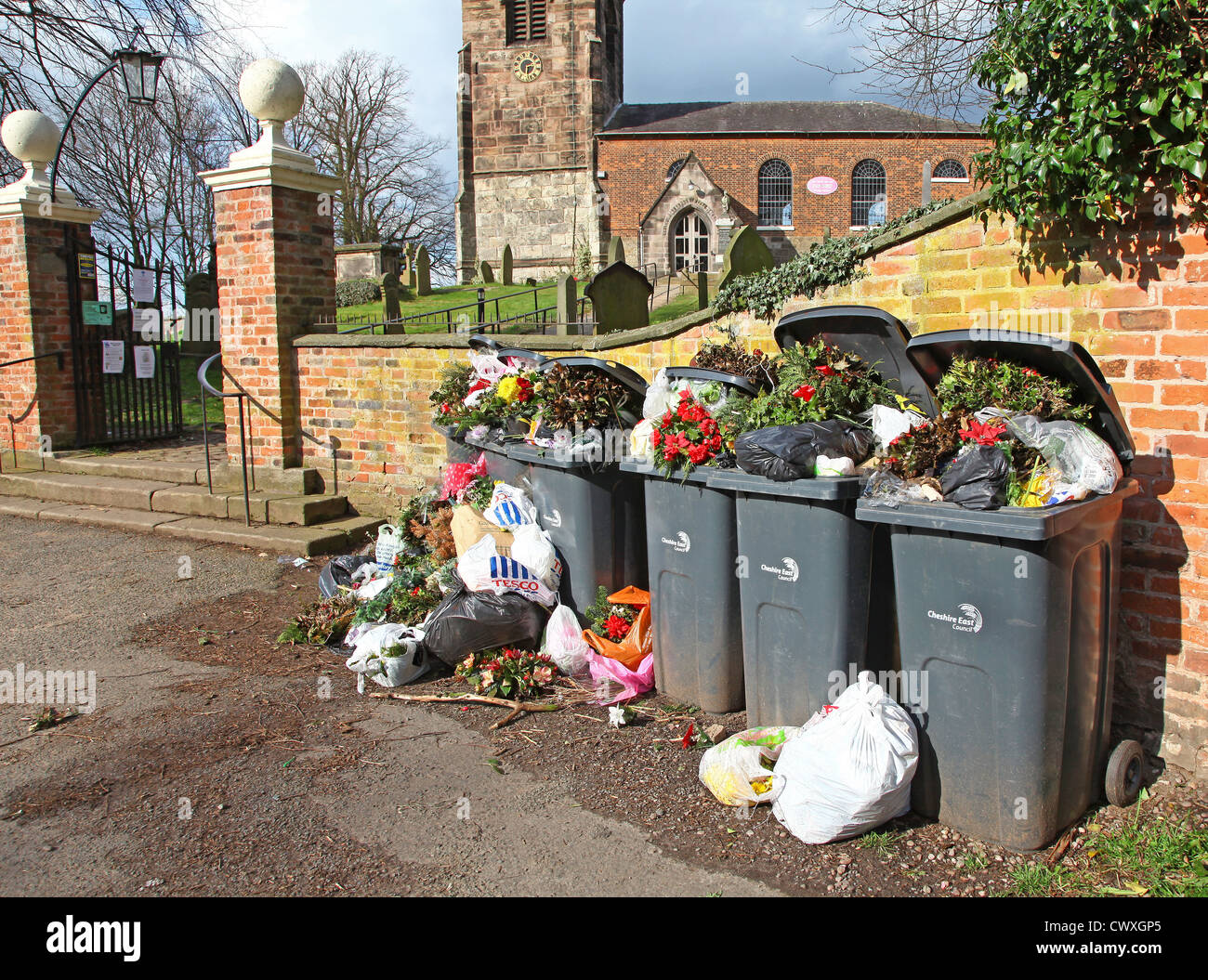 Tote Blumen im Wheelie Behälter außerhalb der Kirchhof an der Pfarrei Kirche der Allerheiligen Kirche Lawton Cheshire England entsorgt Stockfoto