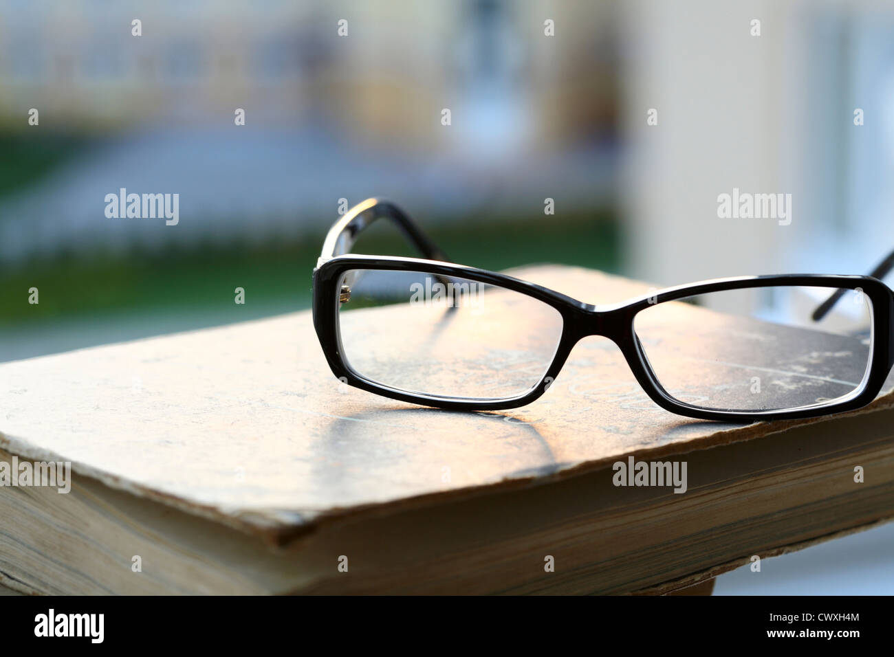 moderne Brillen und altes Buch Stockfoto