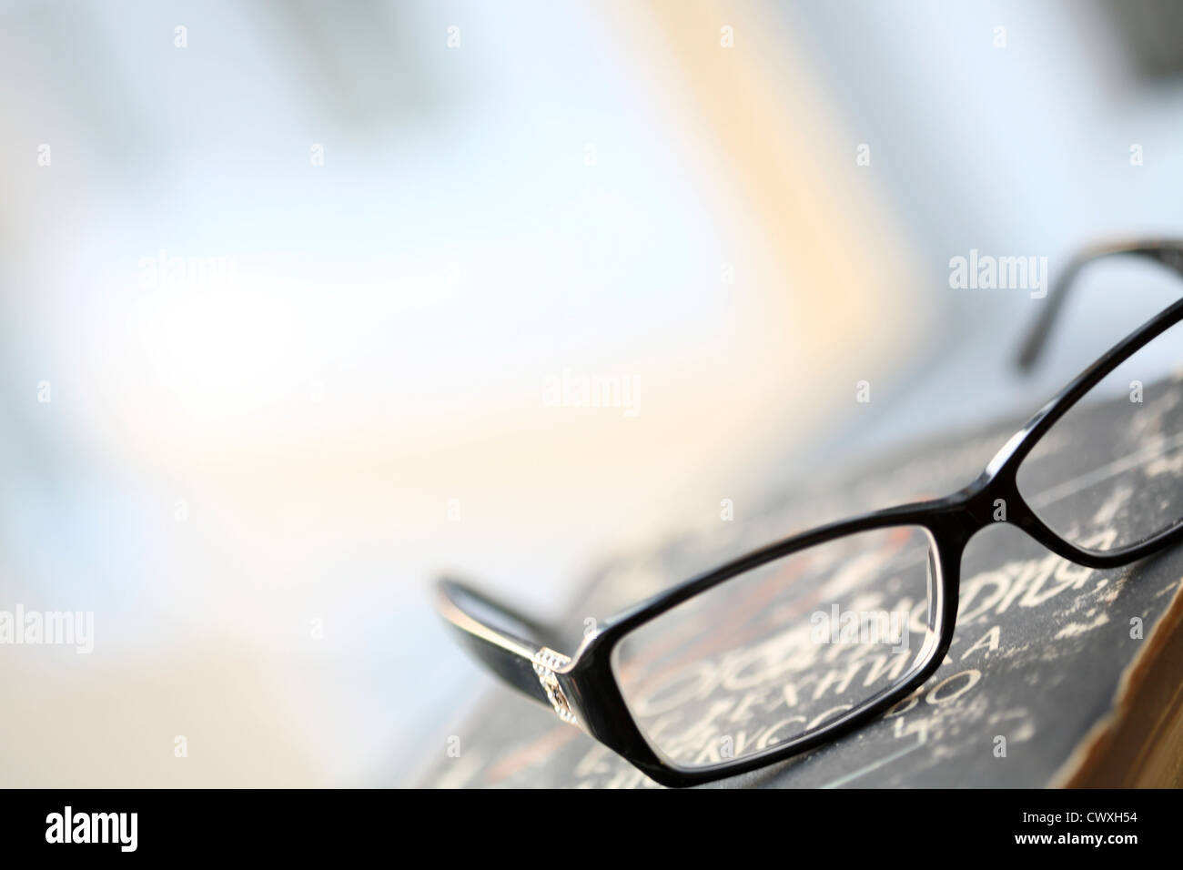 moderne Brillen und altes Buch Stockfoto