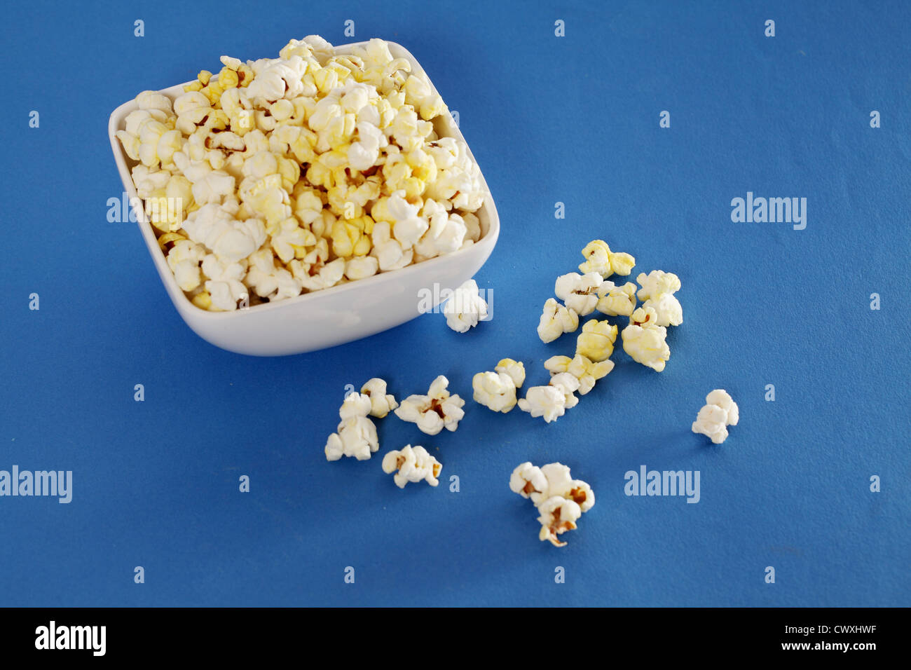 Schale mit leckeren Popcorn auf blauem Hintergrund isoliert Stockfoto