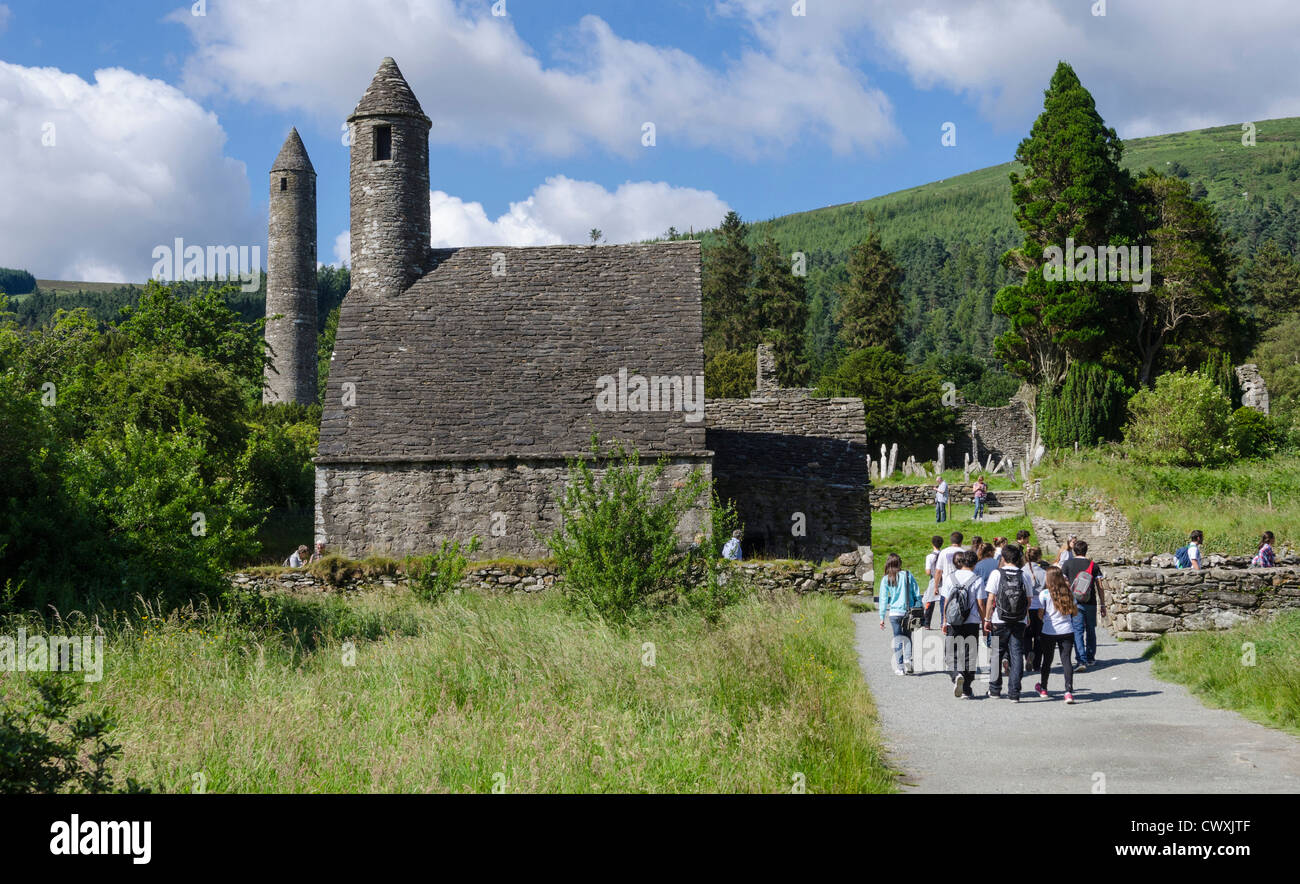 Touristen und Schule Reise nach St Kevins Kirche und Rundturm in Glendalough, County Wicklow, Irland Stockfoto